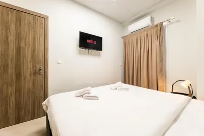 a bedroom with a bed and a tv on the wall at Zeus 2bd 2' minutes walk from Larissa's station in Athens
