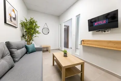 a living room with a couch and a tv on a wall at Zeus 2bd 2' minutes walk from Larissa's station in Athens