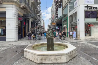 a statue in the middle of a city street at Zen Ermou City Center 1 in Athens