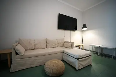 a living room with a couch and a flat screen tv at Athenian Suite Klathmonos by Zeus Suites in Athens