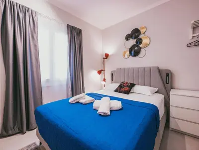a bedroom with a blue bed with towels on it at Aura Suite Stadiou by Zeus Suites in Athens