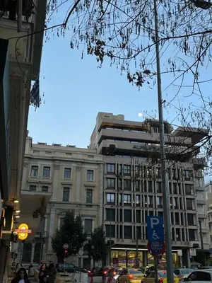 a large building on a city street with cars at Aura Suite Stadiou by Zeus Suites in Athens