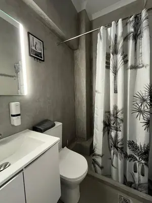 a bathroom with a toilet and a shower curtain at Aura Suite Stadiou by Zeus Suites in Athens