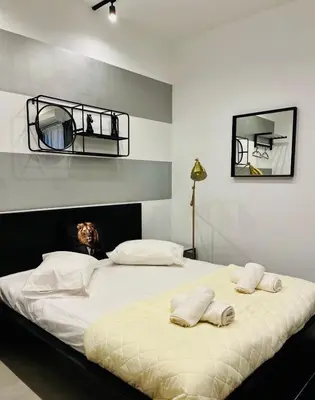 a bedroom with a bed with two towels on it at Poseidon Suite Korai by Zeus Suites in Athens