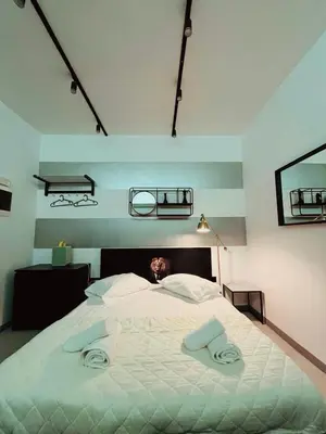 a bedroom with a large bed with two towels on it at Poseidon Suite Korai by Zeus Suites in Athens