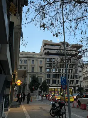 a busy city street with a tall building at Poseidon Suite Korai by Zeus Suites in Athens