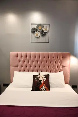 a bed with a pink headboard with a pillow on it at Aphrodite Suite Klathmonos by Zeus Suites in Athens
