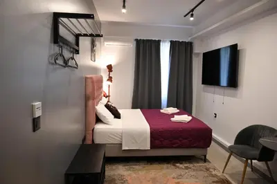 a hotel room with a bed and a tv at Aphrodite Suite Klathmonos by Zeus Suites in Athens