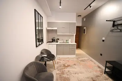 a kitchen with white cabinets and a table and chairs at Aphrodite Suite Klathmonos by Zeus Suites in Athens