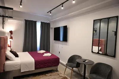 a hotel room with a bed and two chairs at Aphrodite Suite Klathmonos by Zeus Suites in Athens