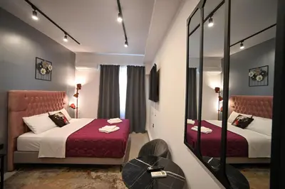 a hotel room with two beds and a mirror at Aphrodite Suite Klathmonos by Zeus Suites in Athens