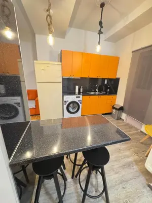 a kitchen with a black counter top and orange cabinets at Athens City Themis 1 in Athens