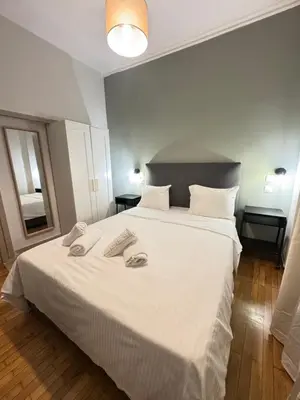 a bedroom with a large white bed with two towels on it at Athens City Themis 1 in Athens