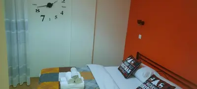 a bedroom with a bed with a clock on the wall at NewRoom2AmbelokipiMetroAirportLine in Athens