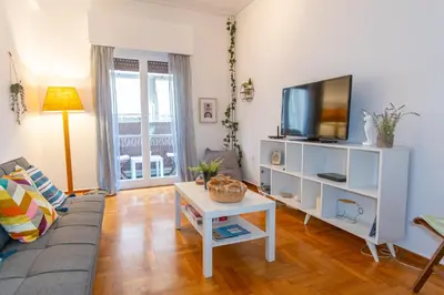 a living room with a couch and a tv at Near Acropolis, Koukaki Retreat in Athens