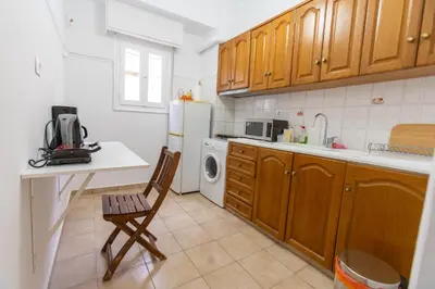 a kitchen with a white refrigerator and a chair at Near Acropolis, Koukaki Retreat in Athens