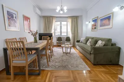 a living room with a table and a green couch at Museum District Apartment in Athens