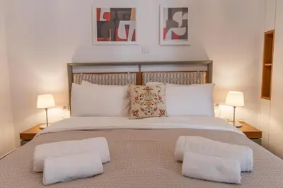 a bedroom with a large bed with two lamps at Museum District Apartment in Athens