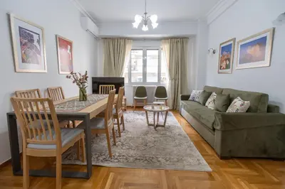 a living room with a table and a green couch at Museum District Apartment in Athens