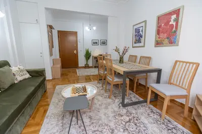 a living room with a couch and a table and chairs at Museum District Apartment in Athens