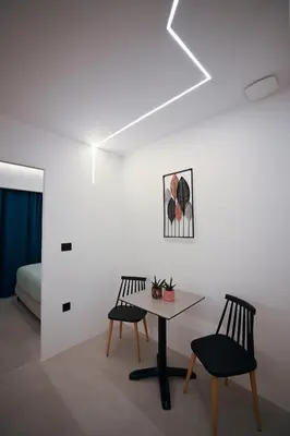 a room with a table and two chairs and a bed at Artemis Patision Suite by Zeus Suites in Athens