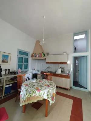 a kitchen with a table and a kitchen with a table and chairs at Sunny apartment next to the Acropolis in Athens