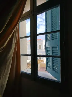 an open window with a view of a building at Sunny apartment next to the Acropolis in Athens