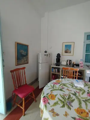 a small kitchen with a table and a refrigerator at CuteStudio in Athens