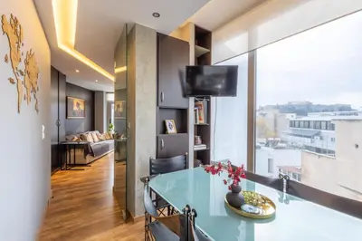 a living room with a table and a large window at Athens Horizon Views Apartment in Athens