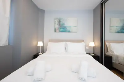 a bedroom with a large white bed with two lamps at Athens Horizon Views Apartment in Athens