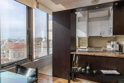 a kitchen with a table and a large window at Athens Horizon Views Apartment in Athens