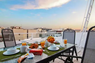 a table with food and orange juice on a balcony at Athens Horizon Views Apartment in Athens