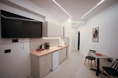 a kitchen with a large flat screen tv on the wall at Apollon Patision Family Suite by Zeus Suites in Athens