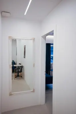 a mirror in a white room with a table at Apollon Patision Family Suite by Zeus Suites in Athens