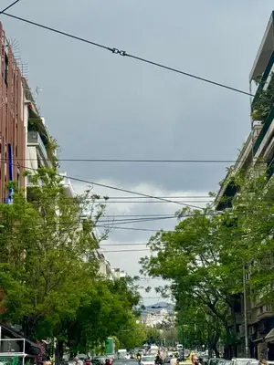 a city street with trees and cars on the road at Apollon Patision Family Suite by Zeus Suites in Athens