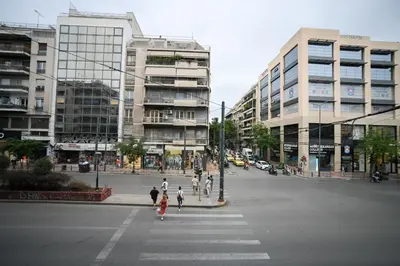 a group of people crossing a street in a city at Erato Pedion Areos Suite by Zeus Suites in Athens