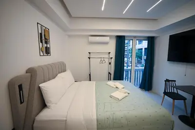 a bedroom with a bed with a table and a television at Erato Pedion Areos Suite by Zeus Suites in Athens