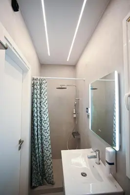 a bathroom with a sink and a mirror and a shower at Museum Pedion Areos Family Suite by Zeus Suites in Athens