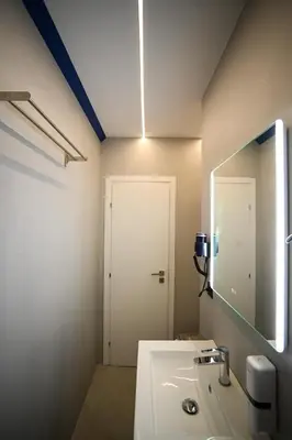 a bathroom with a sink and a mirror and a door at Zeus Elegant Suite by Zeus Suites in Athens