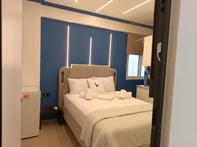 a bedroom with a large bed with blue walls at Family Zeus elegant suite by Zeus suites in Athens