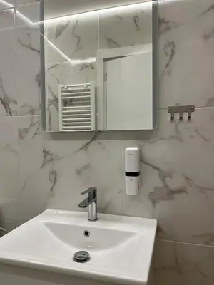 a bathroom with a white sink and a mirror at Family Zeus elegant suite by Zeus suites in Athens