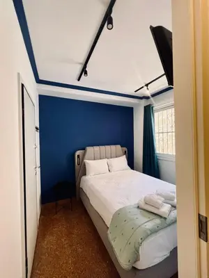 a bedroom with a bed with a blue wall at Family Ermou Suite by Zeus Suites in Athens
