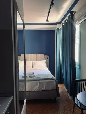 a bedroom with a bed with a blue wall at Family Ermou Suite by Zeus Suites in Athens