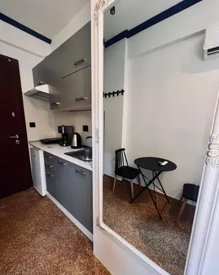 a small kitchen with a table and a mirror at Family Ermou Suite by Zeus Suites in Athens