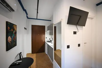 a room with a tv on the wall and a kitchen at Family Ermou Suite by Zeus Suites in Athens
