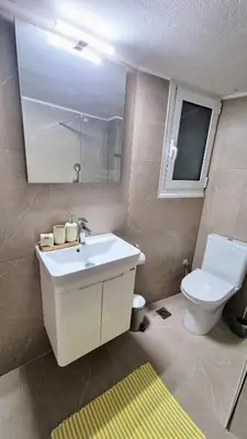 a bathroom with a white sink and a toilet at Mata's Athenian Mosaic - super central city stay in Athens