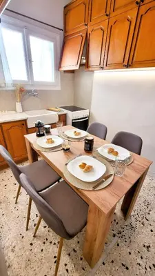 a kitchen with a wooden table with plates of food on it at Mata's Athenian Mosaic - super central city stay in Athens