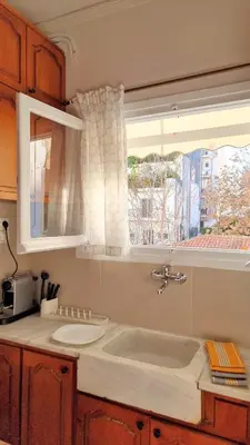 a kitchen with a sink and a window at Mata's Athenian Mosaic - super central city stay in Athens