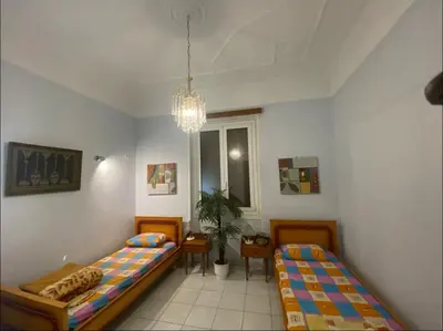 a bedroom with two beds and a chandelier at Athens Apartment IV in Athens