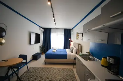 a bedroom with a bed and a kitchen with a sink at Plaka Voulis 45 by Zeus Suites in Athens